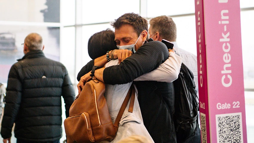 Two people are seen hugging each other after one arrives from a Melbourne flight this morning in Adelaide.