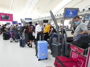 People wait in line to check in at Pearson International Airport in Toronto.