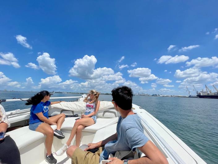 four people sitting on a boat in water