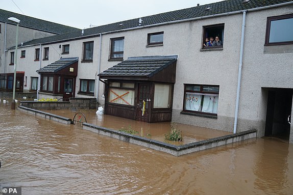 People look out of a window at flood water in Brechin, Scotland, as Storm Babet batters the country. Flood warnings are in place in Scotland, as well as parts of northern England and the Midlands. Thousands were left without power and facing flooding from "unprecedented" amounts of rain in east Scotland, while Babet is set to spread into northern and eastern England on Friday. Picture date: Friday October 20, 2023. PA Photo. See PA story WEATHER Babet. Photo credit should read: Andrew Milligan/PA Wire