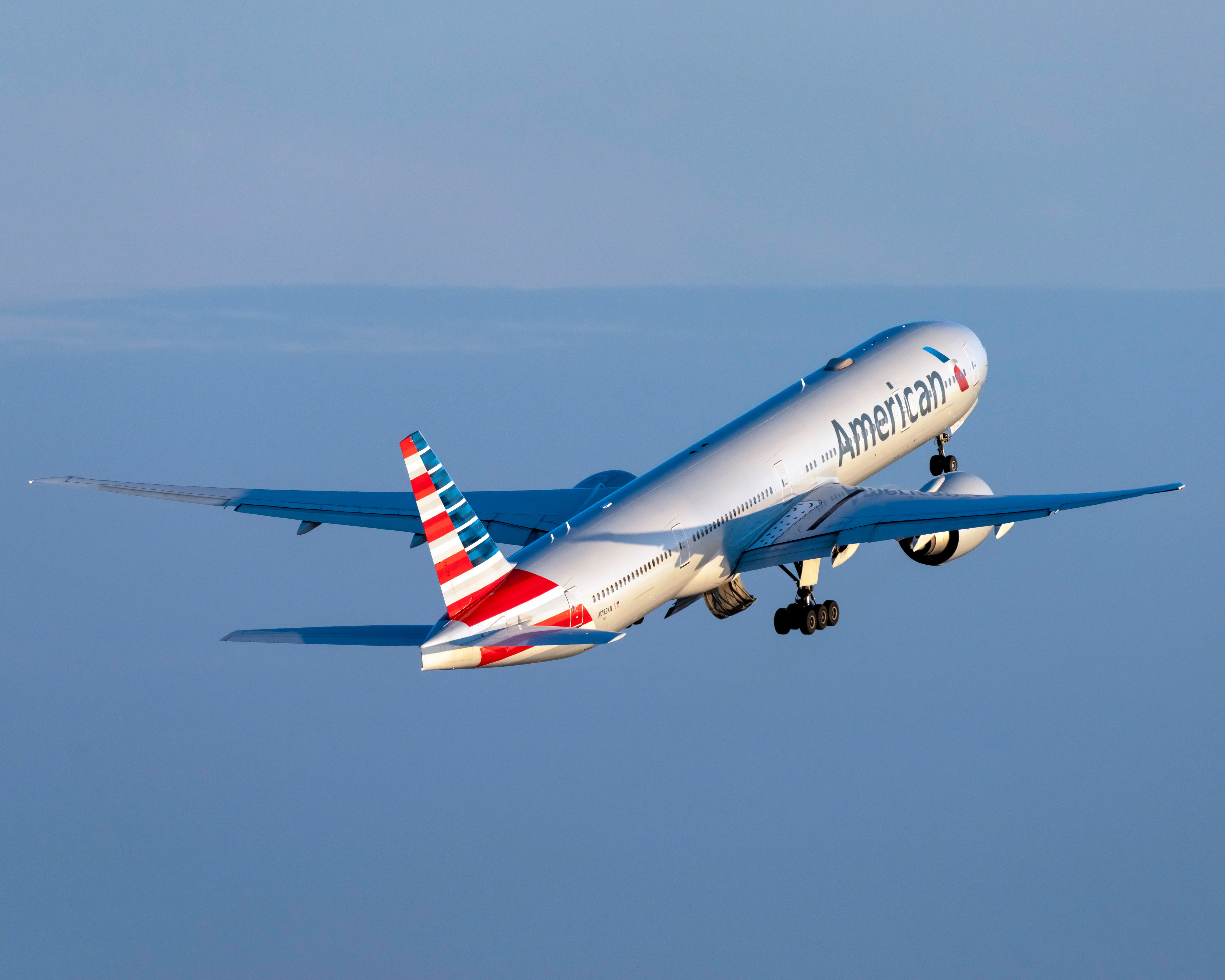 An American Airlines Boeing 777-323(ER) flying in the sky.