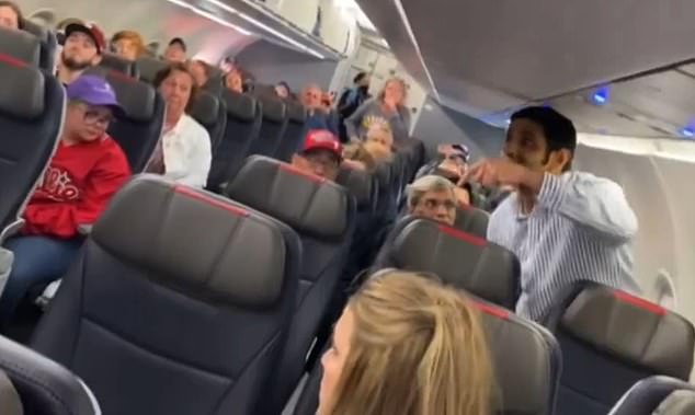 The passenger, dressed in a white and blue striped button down caused a huge scene on the flight as it sat on the runway and was delayed for 30 minutes