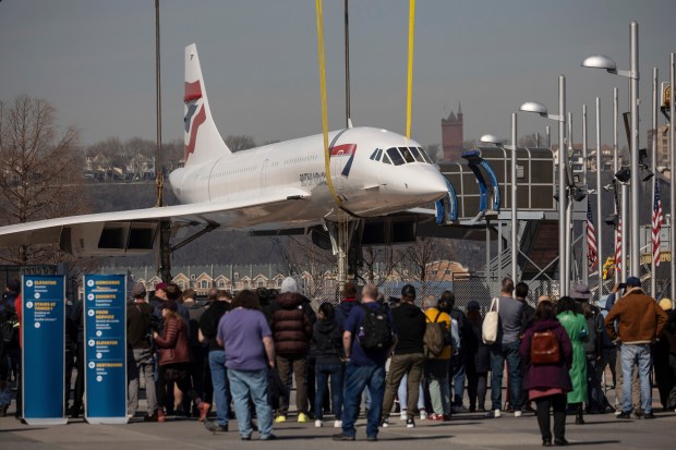 People watch a retired British Airways Concorde supersonic aircraft is lifted by a crane at the Intrepid Museum, Thursday, March 14, 2024, in New York. (AP Photo/Yuki Iwamura)