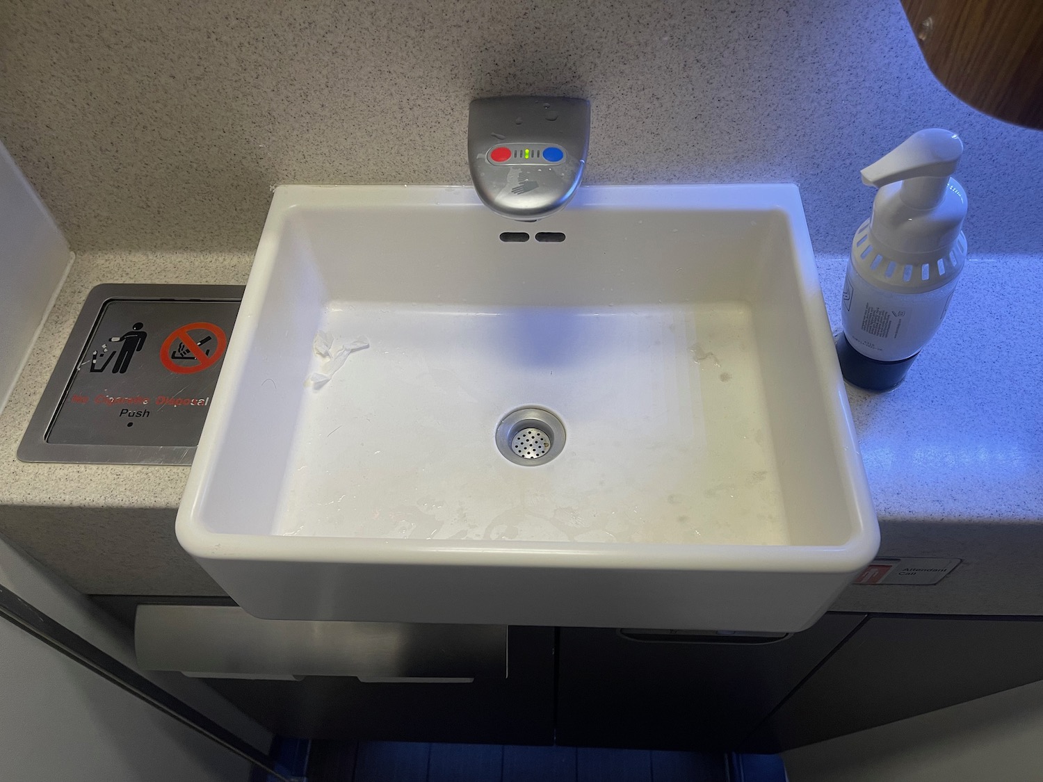 a white sink with a sprayer on the top