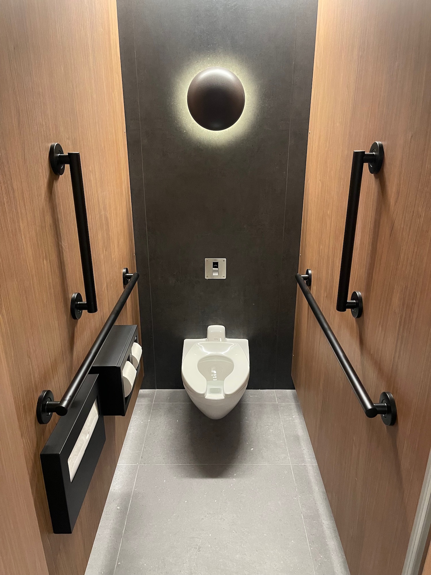 a toilet with a light from the ceiling