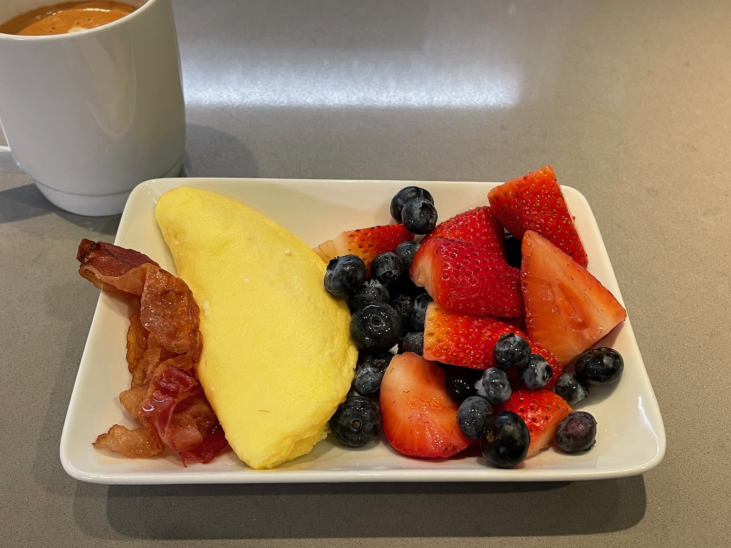 a plate of fruit and bacon
