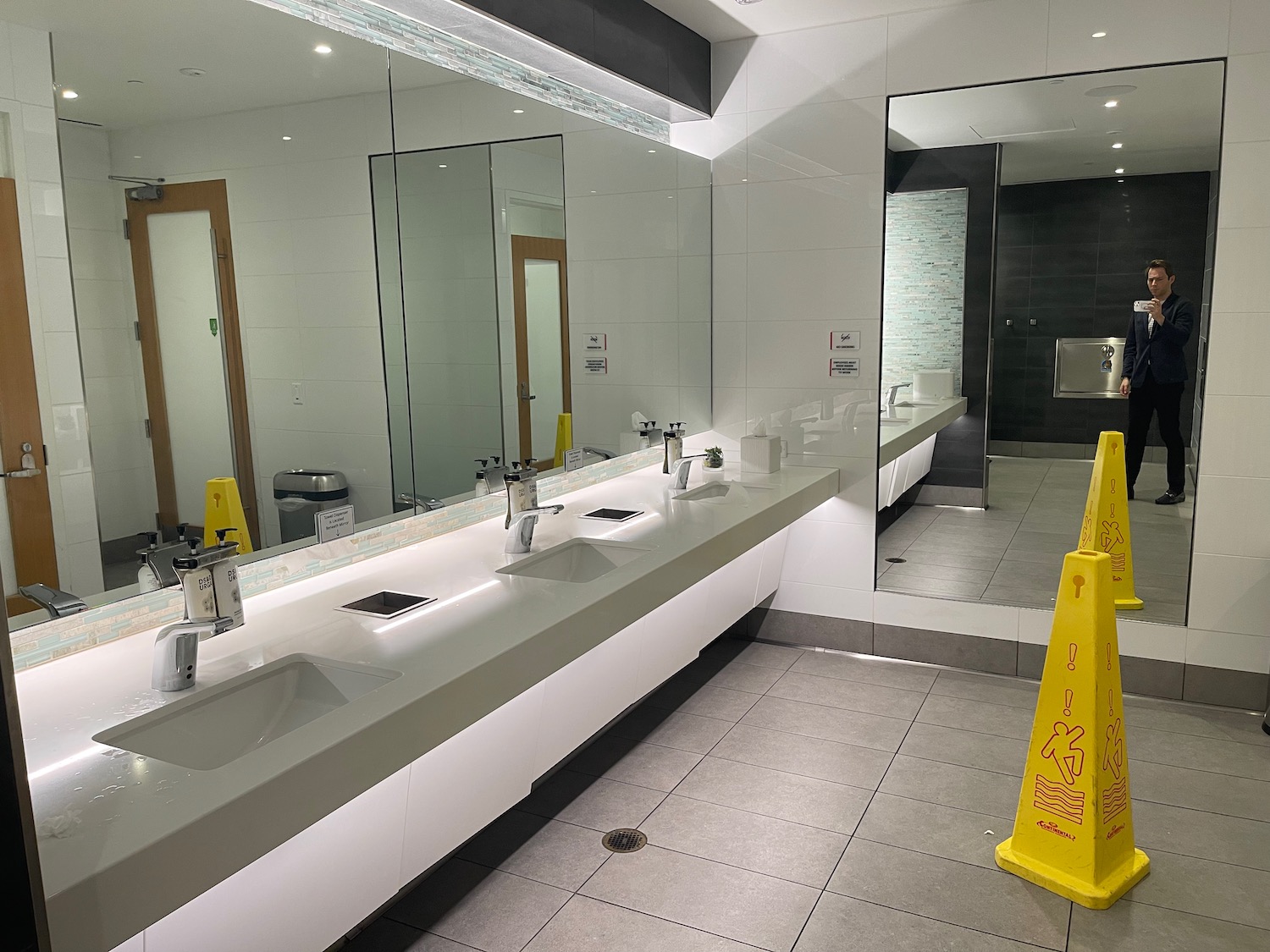 a bathroom with sinks and a yellow sign