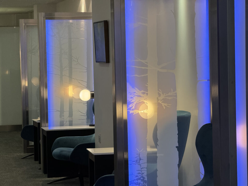 Tree silhouettes on translucent pillars flank the entrance to the lounge.