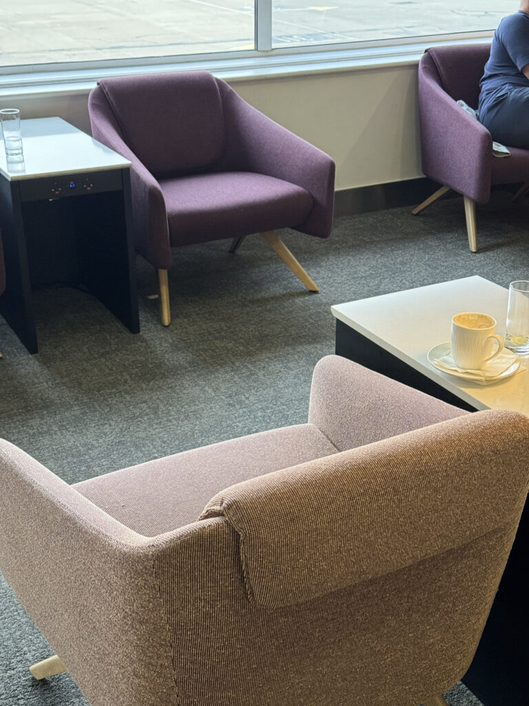 British Airways lounge has various seats in purple and peach.