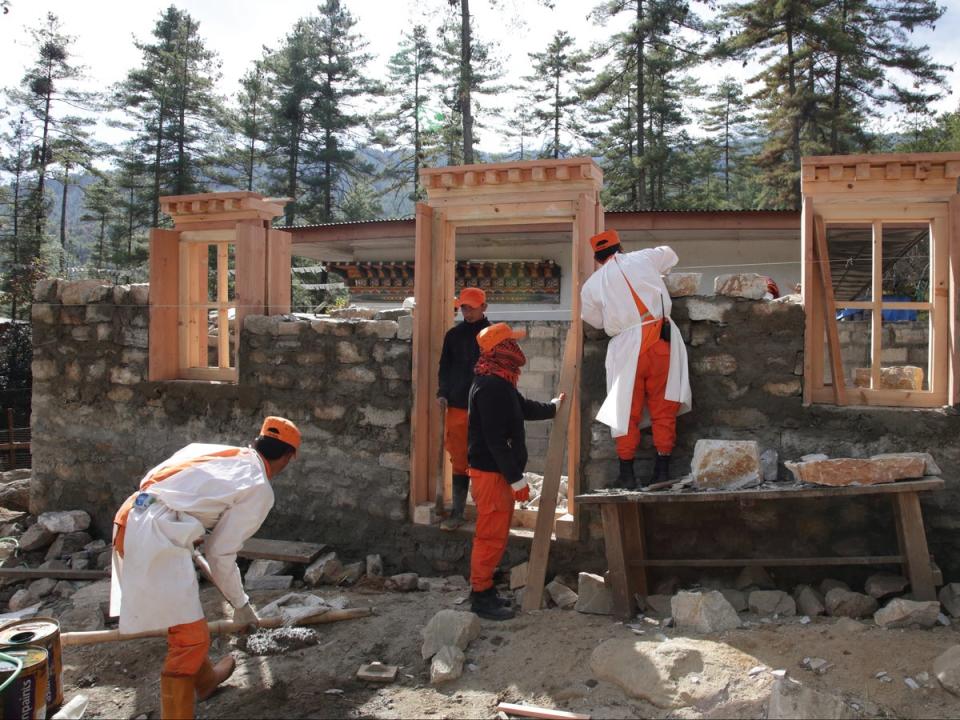 Bhutanese volunteers, always in orange, helping on a building project (Sean Sheehan)