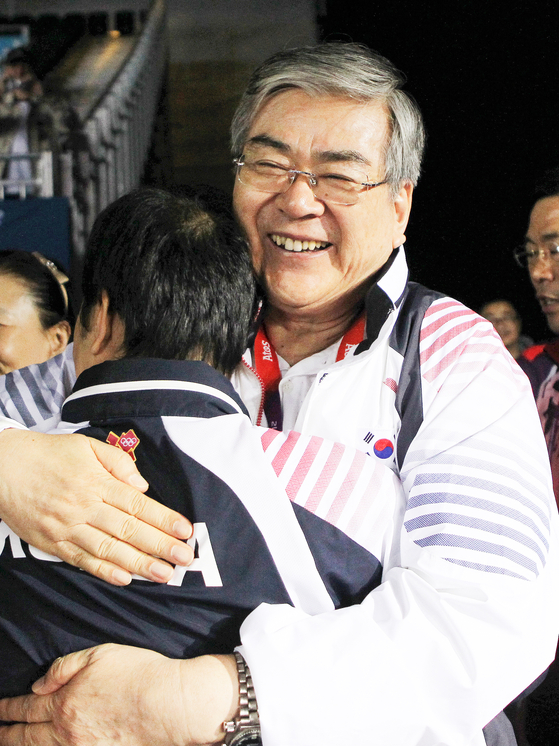 Cho hugs Yoo Nam-kyu, coach for Korea's men's table tennis team, after the team won a silver medal at the 2012 London Summer Olympics. [HANJIN GROUP]