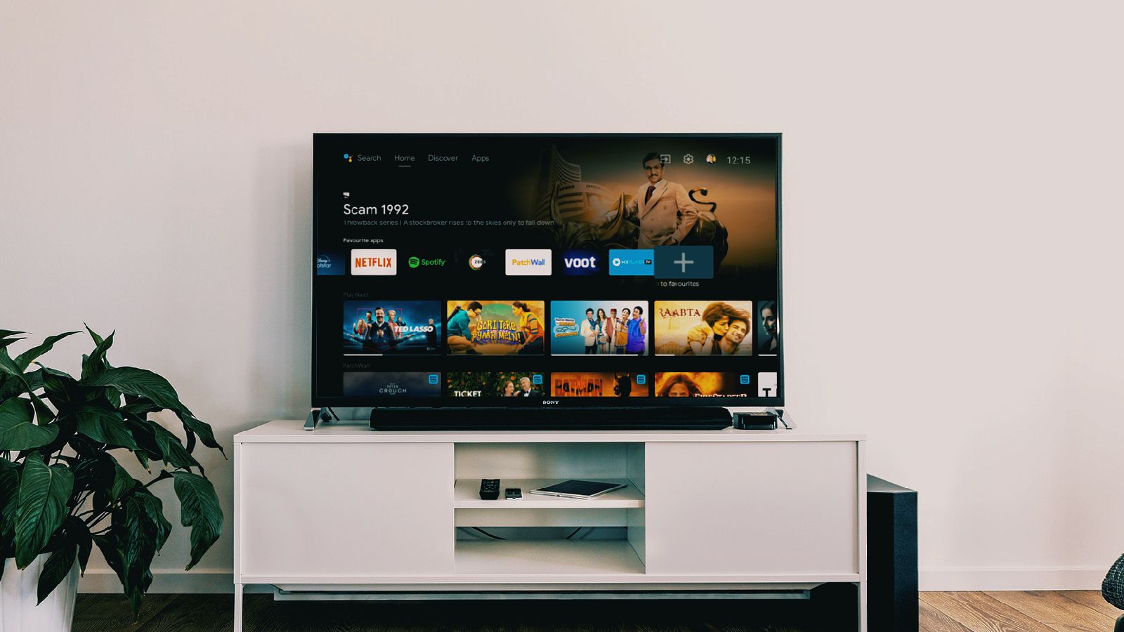 Android TV on a TV on a white cabinet against a white wall.