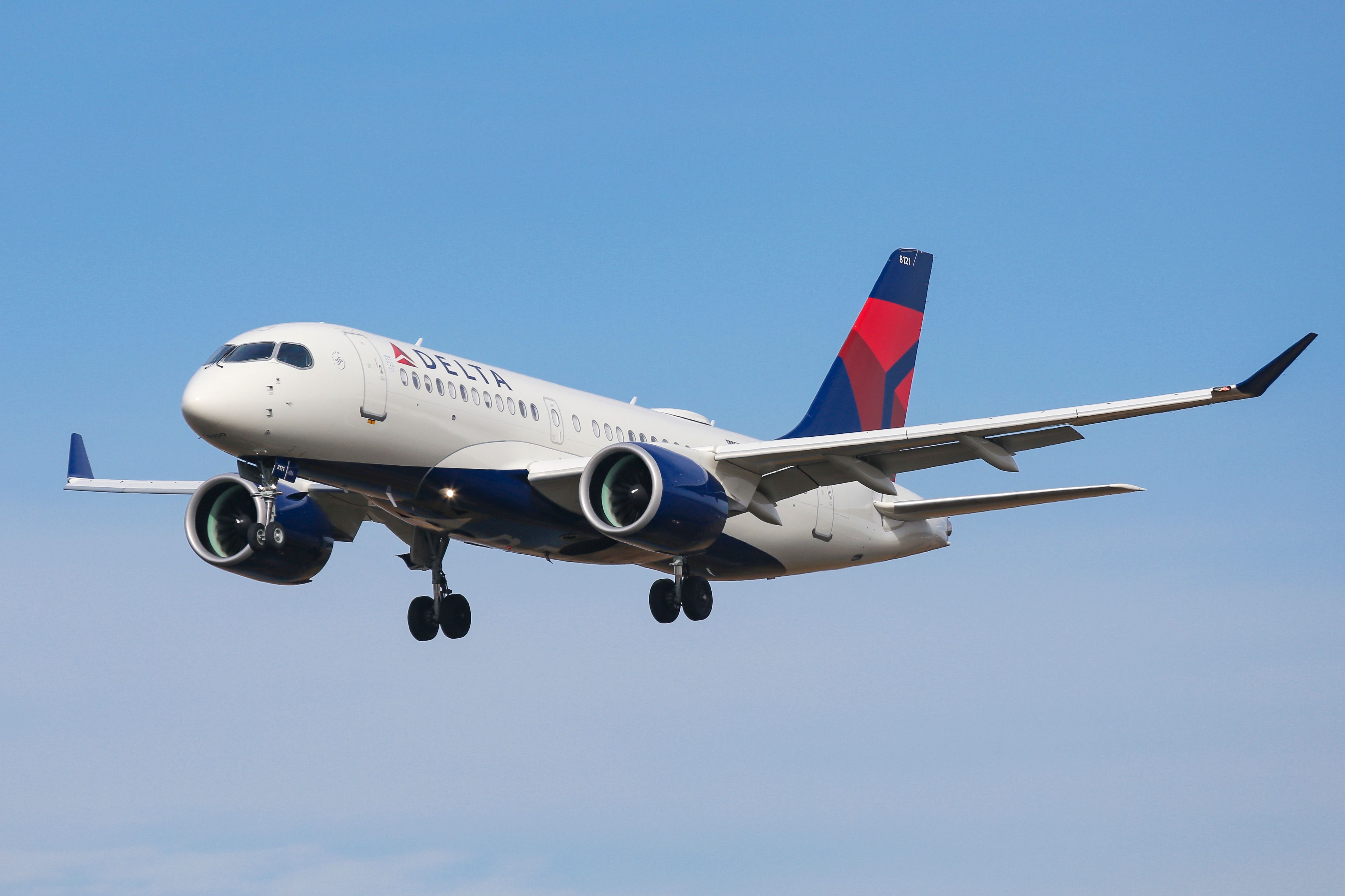 A Delta Air Lines Airbus A220-100 flying in the sky.