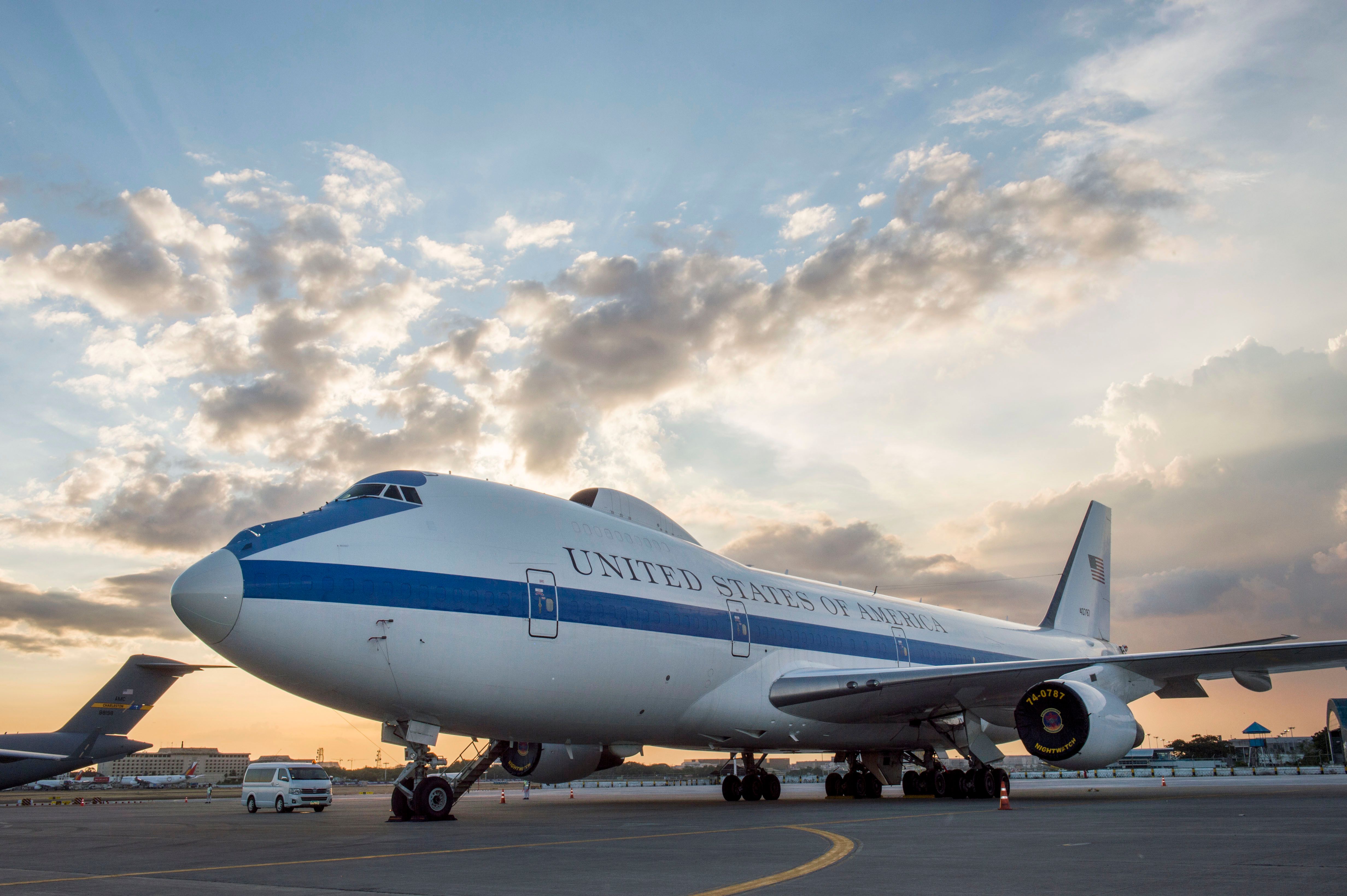 The E-4B Doomsday plane parked at an airport at sunset.