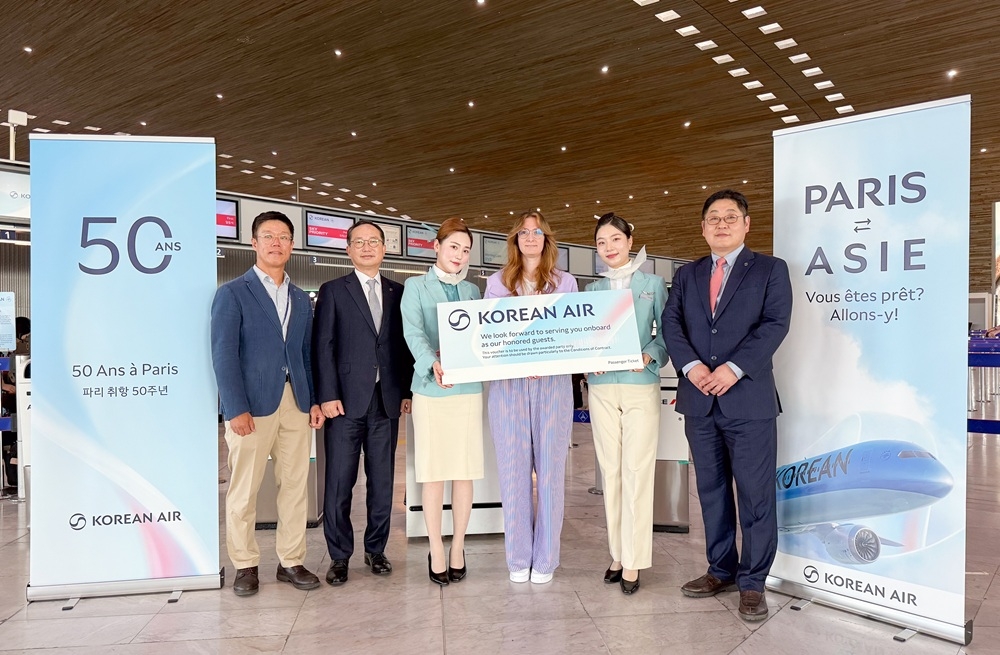 Korean Air officials take a group photo with the recipient of a round-trip ticket at the 50th anniversary celebration of the company's Paris-Seoul Incheon route at the Charles de Gaulle Airport in Paris. [KOREAN AIR]
